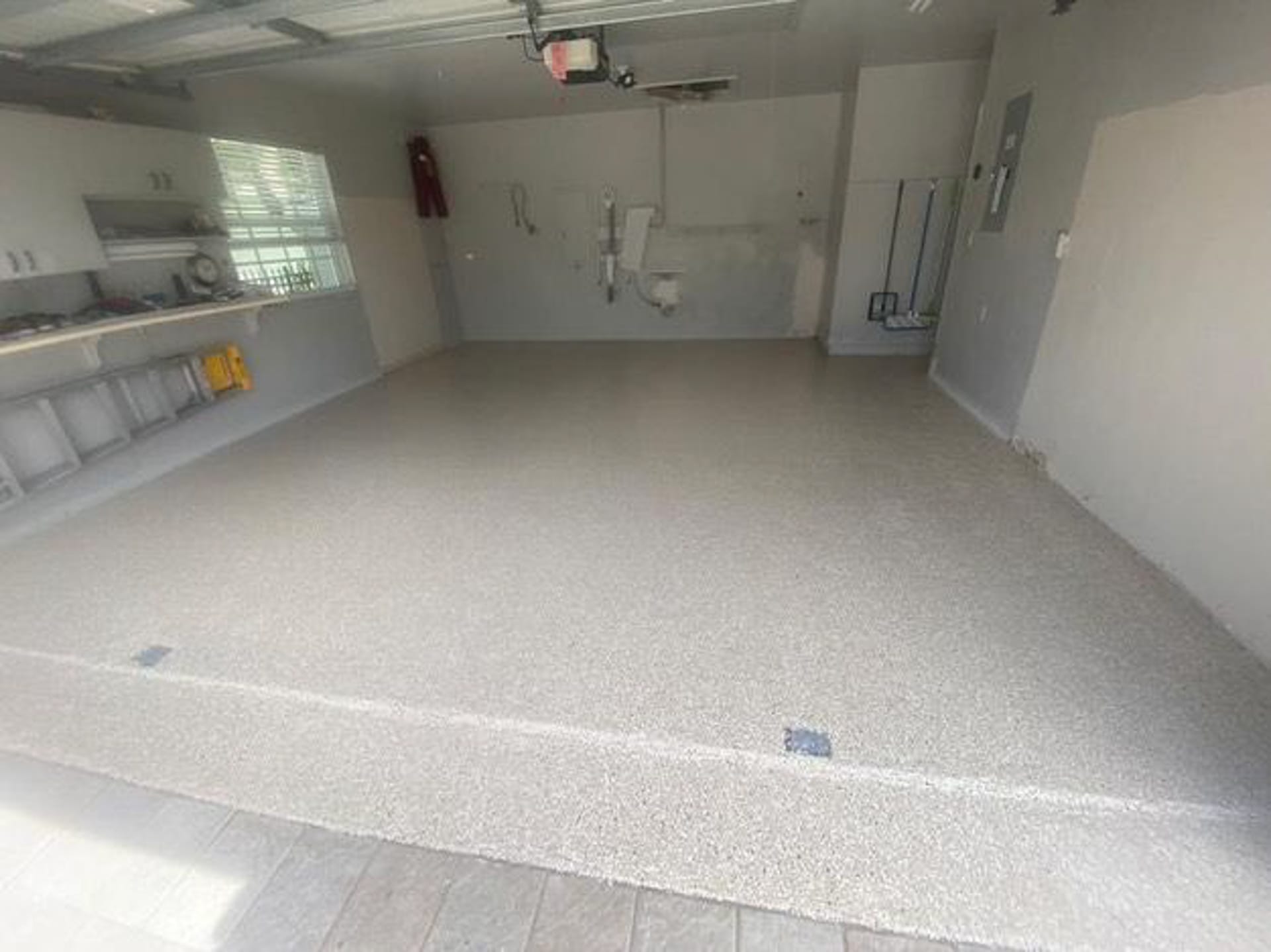 Epoxy-coated garage floor in a Naples, FL home with a glossy flake finish.