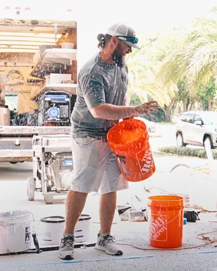 Top Quality Coating technician applying decorative flakes during a polyaspartic epoxy floor installation in Southwest Florida.